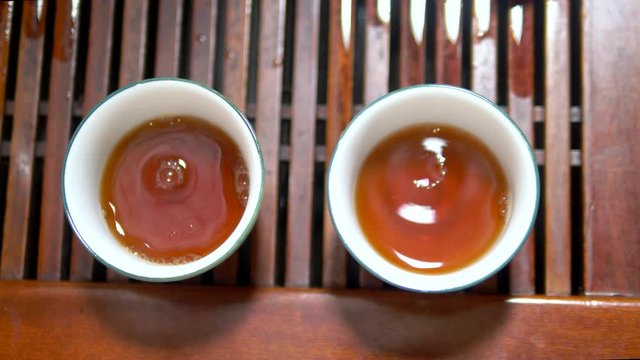 Traditional chinese tea ceremony. close-up. someone pours tea into cups, top view