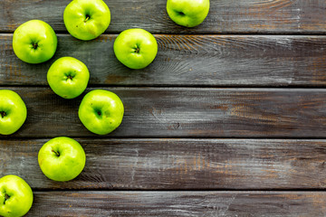 Green apples pattern on dark wooden background top view frame space for text