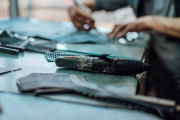 A particular object that is used in the handmade shoe industry, which consists of a very hard stone and a handle and serves to sharpen the blade with which the leather is cut.