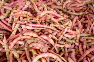 A background of red pea pods on display at a local grocery store.