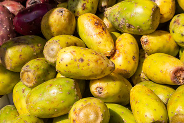 Several prickly pear fruit on display at a local farmers market.