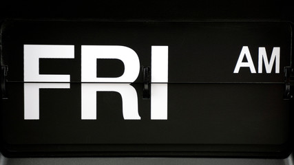 Close-up Flip clock label Friday pm. on Black background, Time concept.