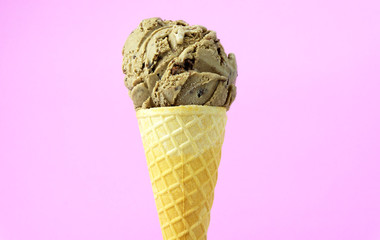 Ice cream mocha scoop in waffle cone on pink background, Closeup Front view Food concept..