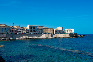 Fototapeta na wymiar The sea wall protecting the island of Ortygia at Syracuse on the Italian island of Siciy