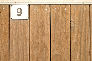 9, number nine, metal plate on wooden teak deck.