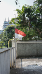 Indonesian red and white flag fluttering half-mast mourning