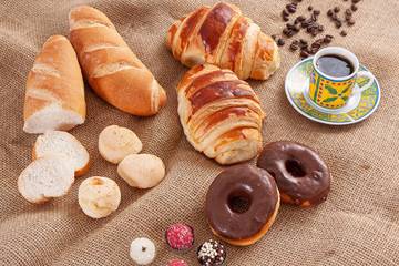 Breakfast with Italian bread, cheese bread, chocolate donut, coffee and croissant