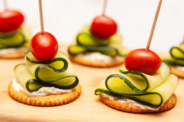 Crackers served with cucumber slices and baby tomatoes