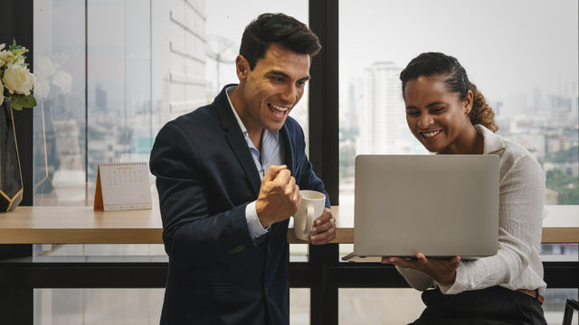 diverse business people having business conversation during coffee break time with laptop computer and cup of coffee at window corner in office