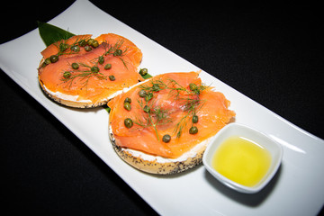 a healthy smoked salmon and cream cheese bagel served with a helping of garlic olive oil