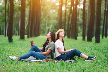 Two women sitting in the woods with feeling relaxed