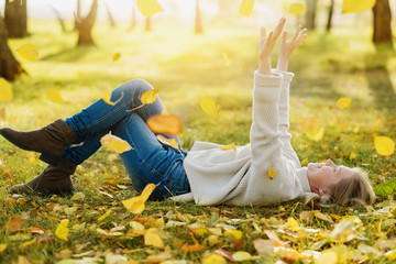 Beautiful Autumn Woman with Autumn Leaves on Fall Nature Background