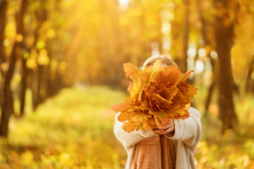 Beautiful Autumn Woman with Autumn Leaves on Fall Nature Background.