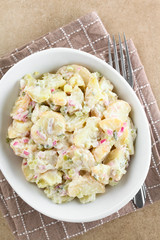 Fresh homemade vegetarian potato salad made with red onion, pickles, mayonnaise and mustard, served...