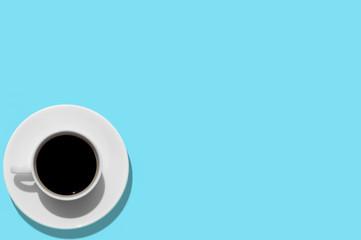 Cup with coffee on aquamarine background. Free space. Isolated. Top view.