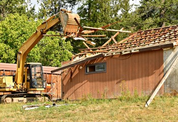 Excavator destroying house