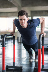 Fototapeta na wymiar Handsome man and strong guy doing push ups exercise in fitness gym