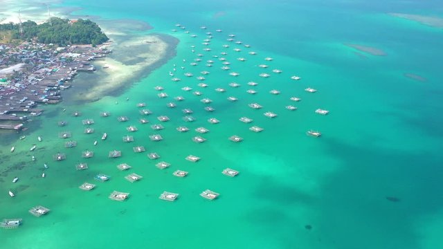 Aerial Drone Video flying above Fishing Village of Tanjung Binga in Belitung Island Indonesia. Fishing Boat on Clear water, village houses