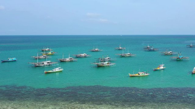 Aerial Drone Video flying above Fishing Village of Tanjung Binga in Belitung Island Indonesia. Fishing Boat on Clear water, village houses