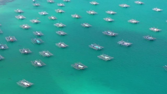 Aerial Drone Video flying above Fishing Village of Tanjung Binga in Belitung Island Indonesia. Fishing Boat on Clear water, village houses