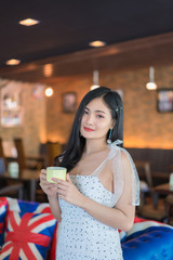 Portrait of smiling woman drinking coffee at vintage cafe