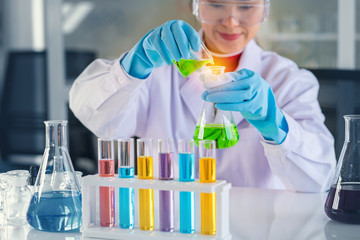 scientist with equipment and science experiments, laboratory glassware containing chemical liquid...