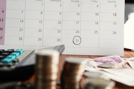 debt collection and tax season concept with deadline calendar,coins,calculator on table