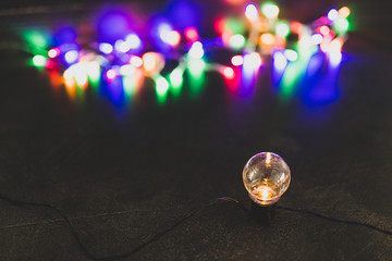 one unique lightbulb metaphor of good idea standing out from the crowd with group of others in the background with psychedelic lights