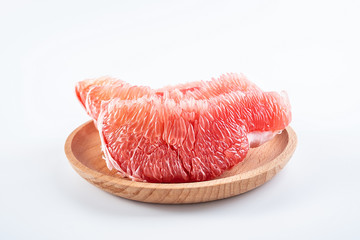 a plate of fresh red grapefruit meat on a white background