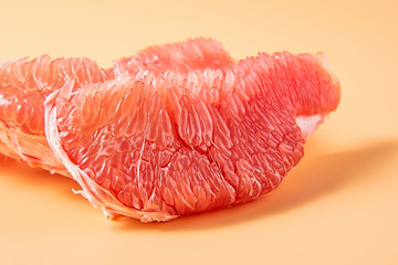 Fresh red grapefruit meat close-up on a yellow background