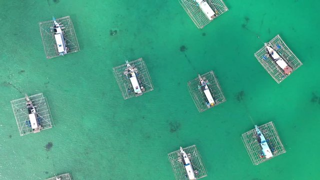 Aerial Drone Video flying above Fishing Village of Tanjung Binga in Belitung Island Indonesia. Fishing Boat on Clear water, village houses