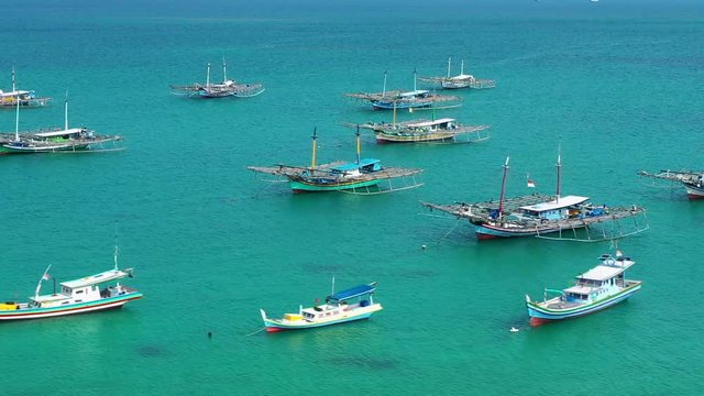 Aerial Drone Video flying above Fishing Village of Tanjung Binga in Belitung Island Indonesia. Fishing Boat on Clear water, village houses