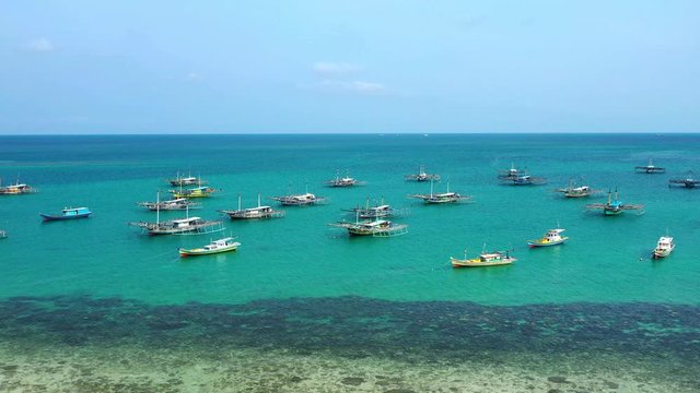 Aerial Drone Video flying above Fishing Village of Tanjung Binga in Belitung Island Indonesia. Fishing Boat on Clear water, village houses