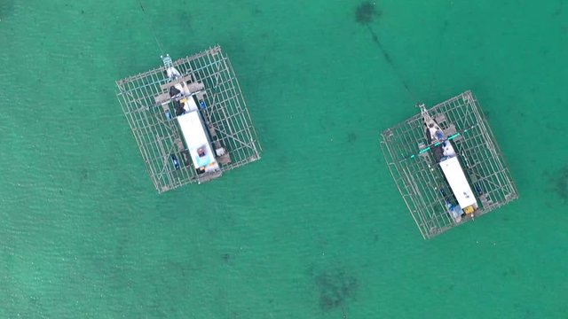 Aerial Drone Video flying above Fishing Village of Tanjung Binga in Belitung Island Indonesia. Fishing Boat on Clear water, village houses