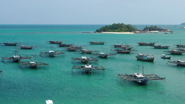 Aerial Drone Video flying above Fishing Village of Tanjung Binga in Belitung Island Indonesia. Fishing Boat on Clear water, village houses