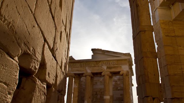 Time Lapse of shadows and the sun appearing behind the ancient temple of Athena Nike in the Acropolis in Athens, Greece
