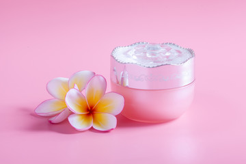 Plumeria flower cosmetics on a pink background