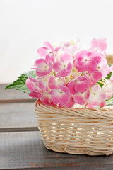 Fototapeta na wymiar Pink hortensia flowers in white wicker basket.