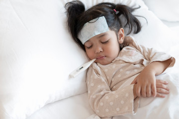 Medical check up and treatment concept. Mother is measure the temperature of little Asian kid girl. Sick child with fever and illness in bed.