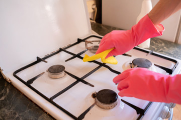 cleaning service washing the cooker stove at home