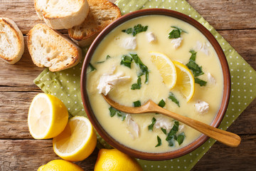 Thick aromatic Greek lemon soup with chicken and orzo paste close-up in a bowl. Horizontal top view