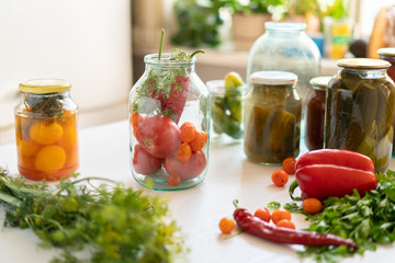 many jars with pickled vegetables mix inside, preparation for winter season