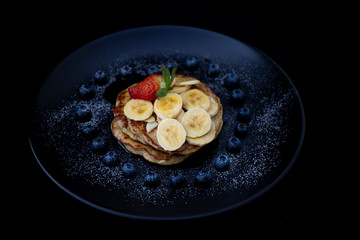 Healthy banana pancake with blueberry heart shape and strawberry
