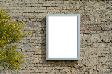 Blank white mock up template of poster with steel frame on old brick wall. Background texture for information/advertisement board.