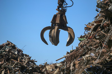 Close up industrial claw machine, move scrap metal in the landfill. Excavator arm, claw crane.