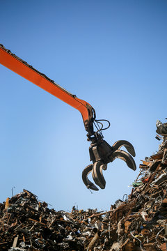 Industrial claw machine, move scrap metal in the landfill. Excavator arm, claw crane.