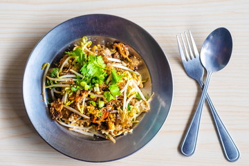 Top view selective focus of Crisp Fried Mussels Pancake in plate on wooden table with spoon and fork , Traditional thai seafood.