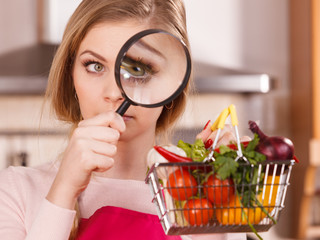 Woman investigating shopping backet with vegetables