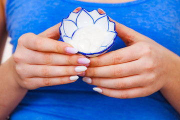 Girl holds bowl with cream cosmetic