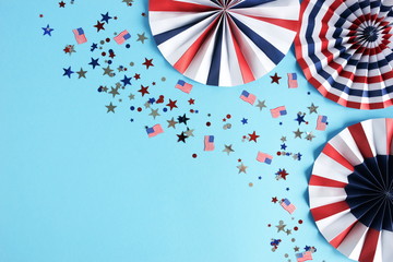 Obraz premium 4th of July American Independence Day, celebration, patriotism and holidays party concept from paper fans and confetti usa flag colors top view on blue background. Copy space 
